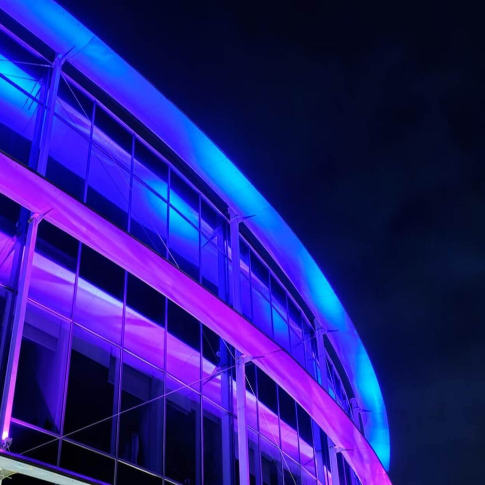 
                      
                        building at night illuminated in blue and purple by led neon strips
                      
                    